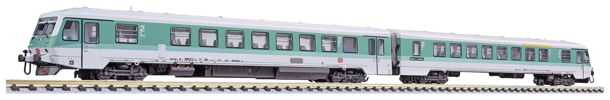 Un train vert et blanc est stationné sur les voies. Le train possède deux wagons avec de nombreuses fenêtres et une façade moderne.