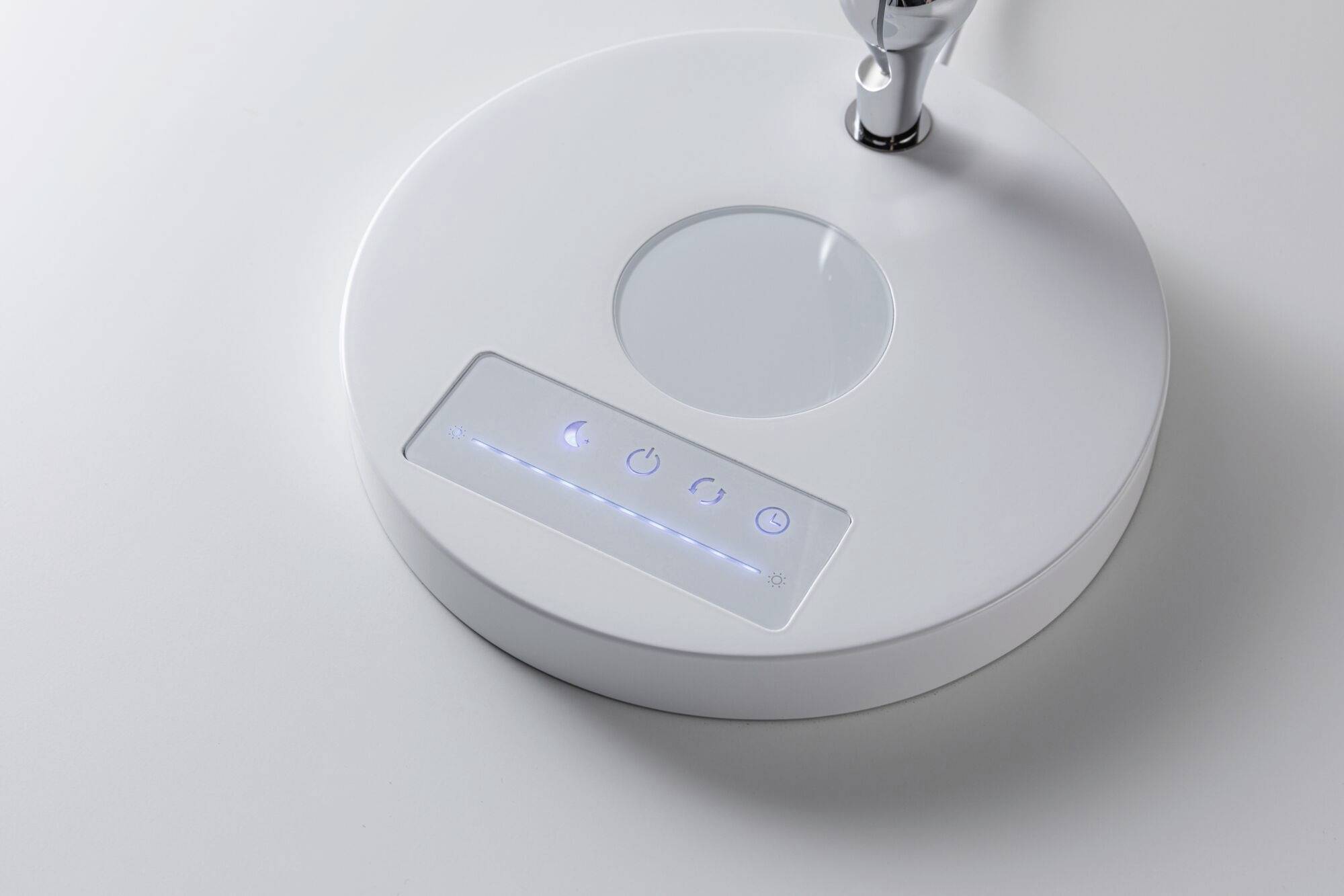 Un robinet blanc et rond avec des indicateurs LED et un panneau de commande tactile pour le contrôle de l'eau sur une surface plane.