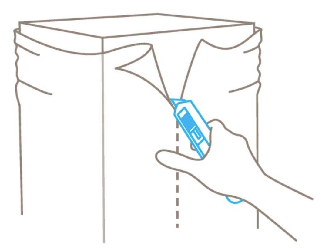 Une main utilise un cutter pour ouvrir le dessus d'un carton le long de la ligne tracée.