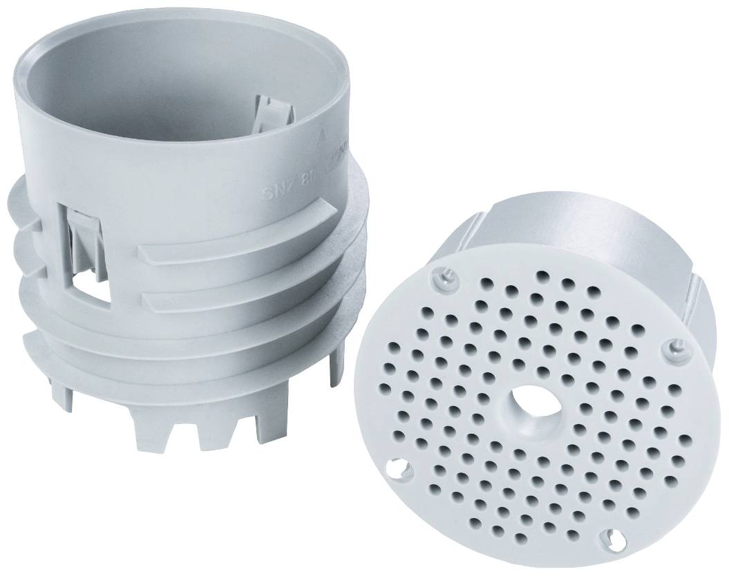 Deux pièces en plastique cylindriques grises. À gauche, un insert avec des fentes, à droite, un couvercle perforé avec un trou central.