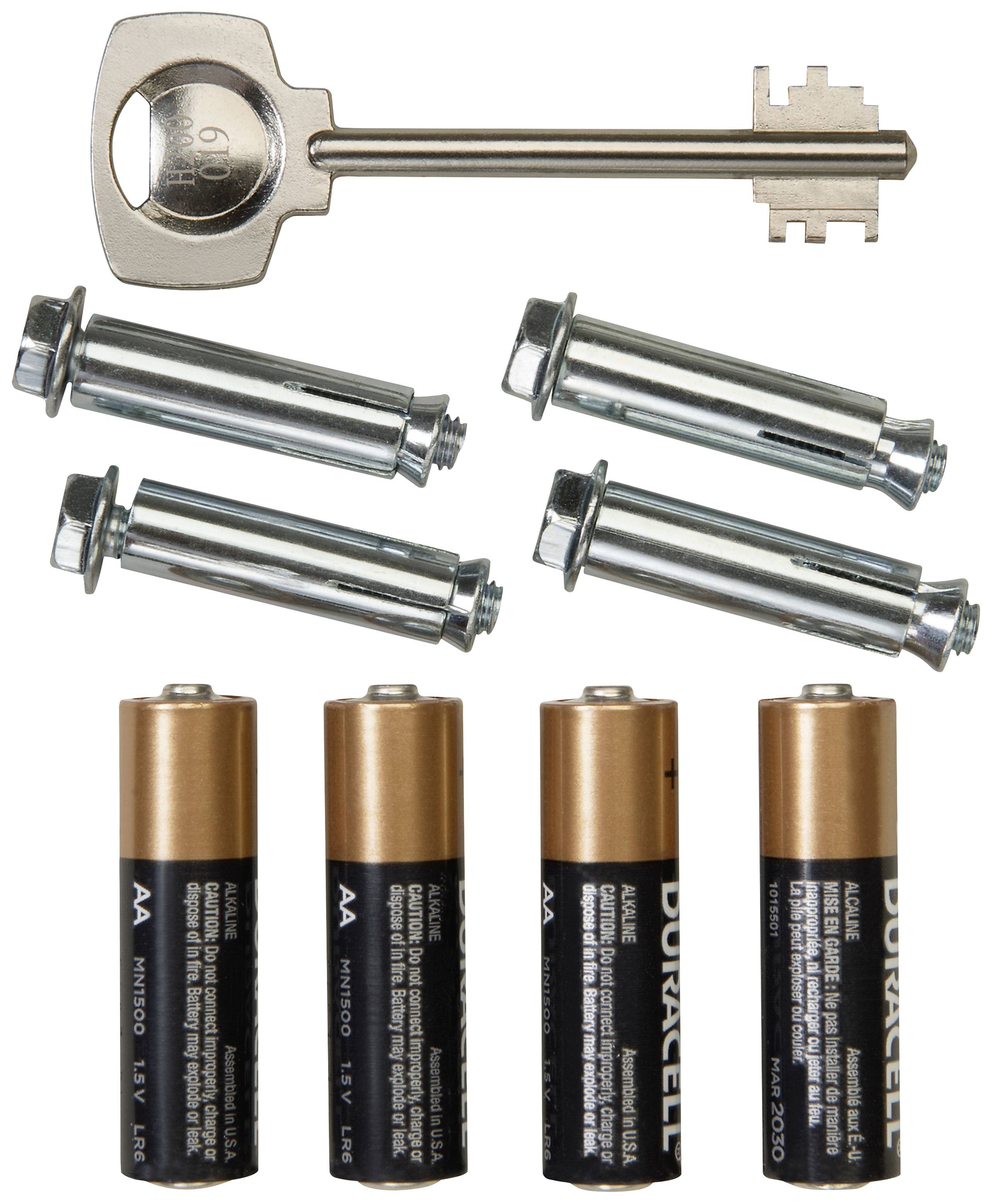 Une clé métallique, quatre boulons métalliques et quatre piles AA disposés côte à côte sur une surface blanche.