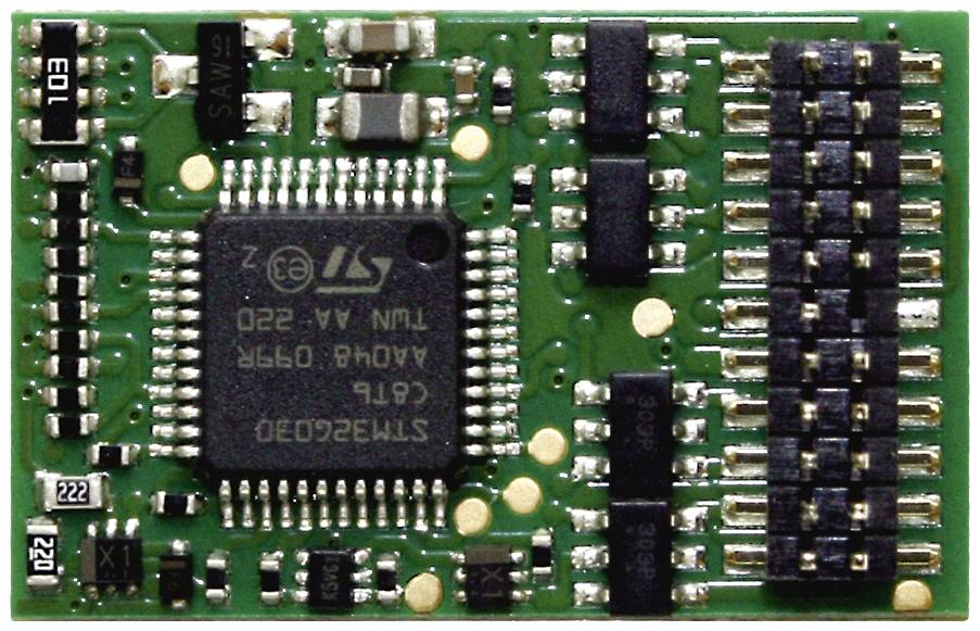 Une carte de microélectronique verte comportant plusieurs puces IC et résistances. Puce principale marquée 'ST' au centre.