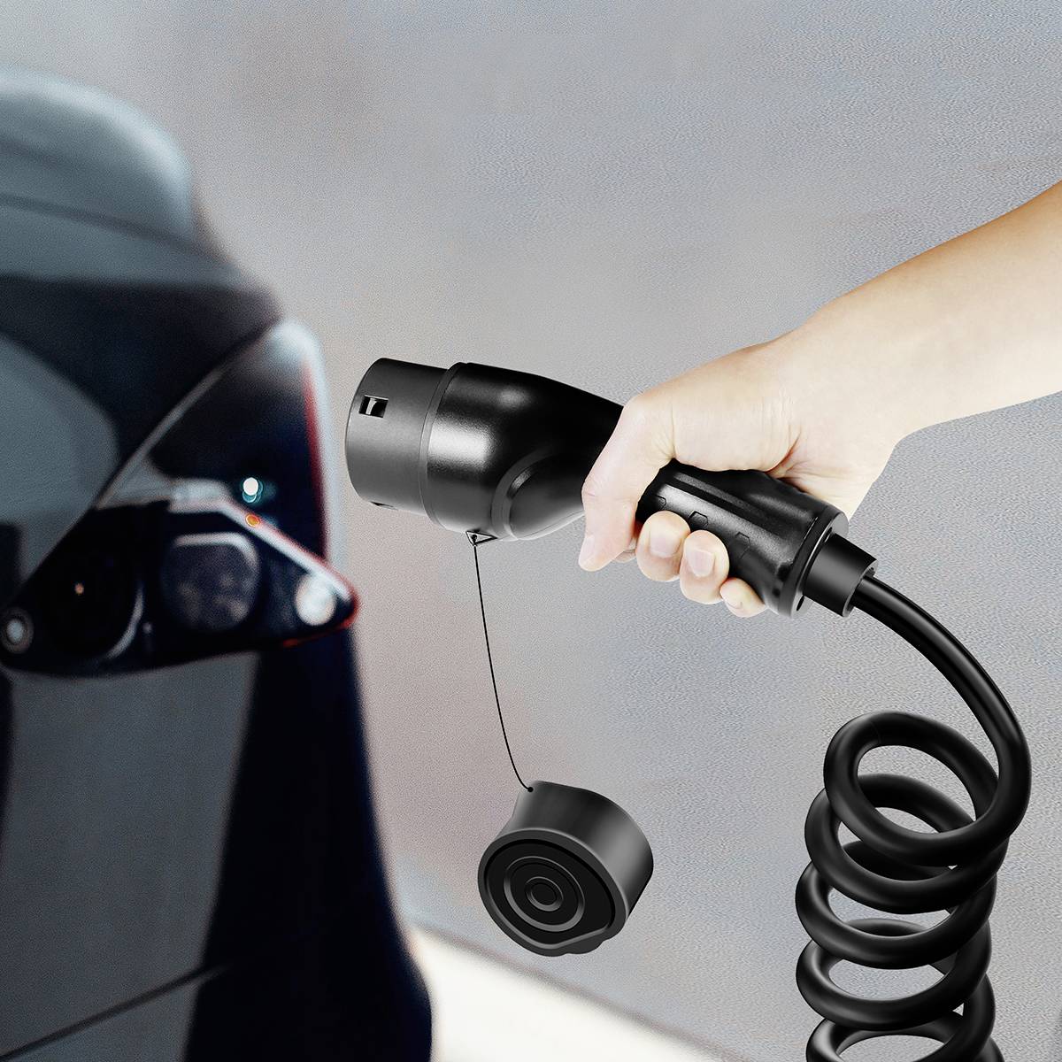 Une main tient un câble de charge et le branche à un véhicule électrique. La scène montre le rechargement d'une voiture électrique.