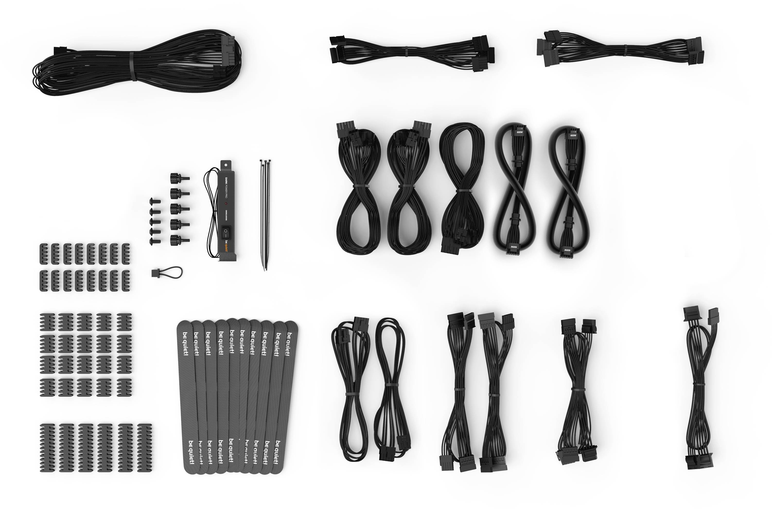 Un ensemble de câbles noirs de différents types et tailles, accompagné de vis et de matériel de fixation pour le matériel informatique.