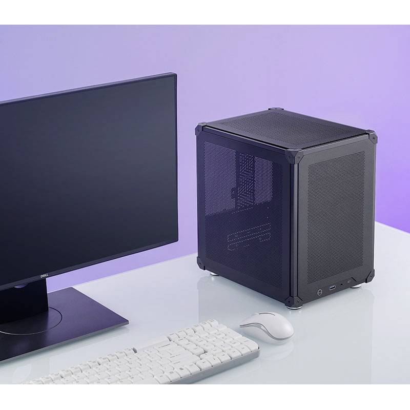 Un moniteur, un clavier et une souris sont posés sur une table à côté d'un petit boîtier d'ordinateur carré.