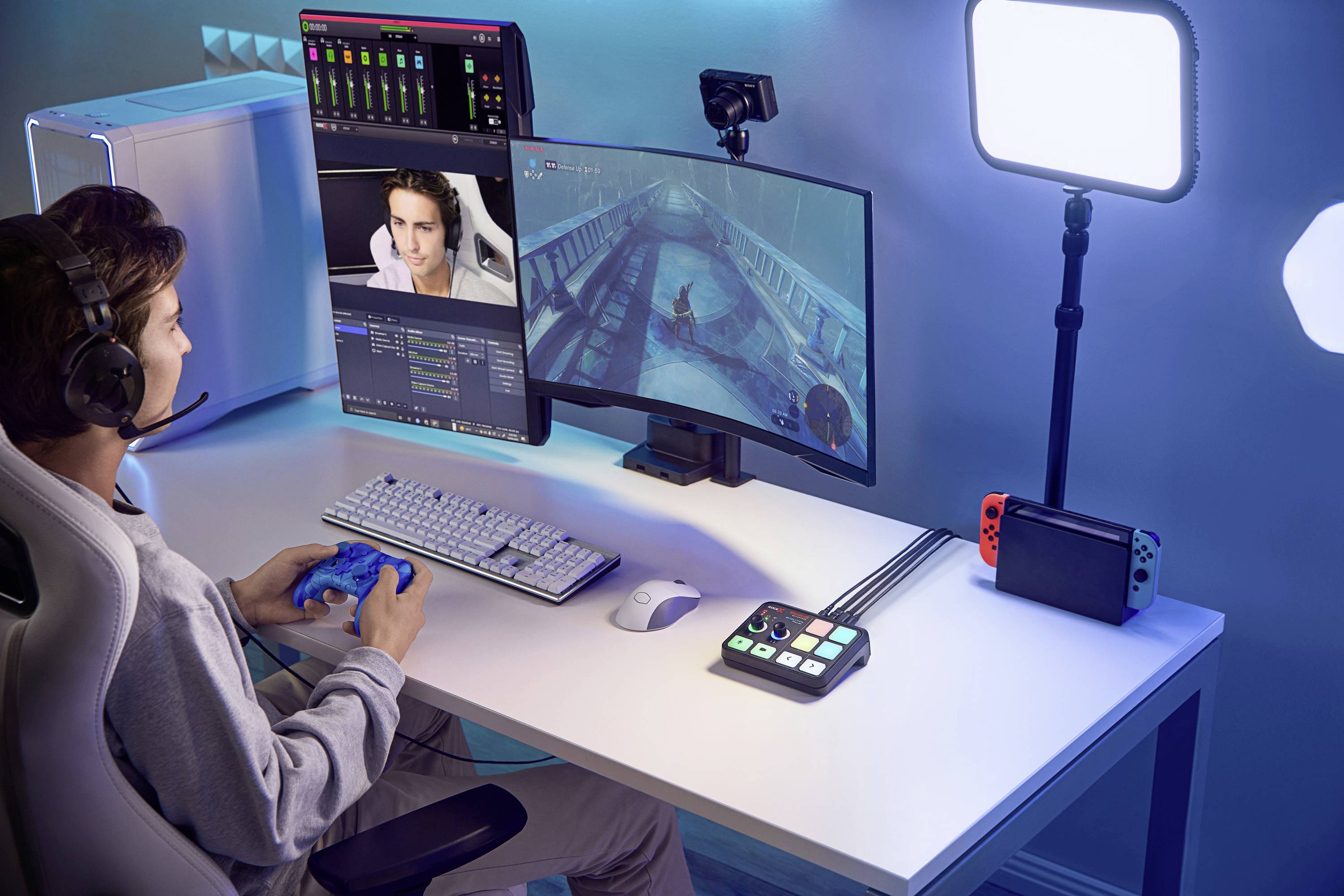 Un homme joue à un jeu vidéo sur ordinateur. Il porte un casque et diffuse en direct. Sur la table se trouvent des accessoires de gaming et un éclairage.