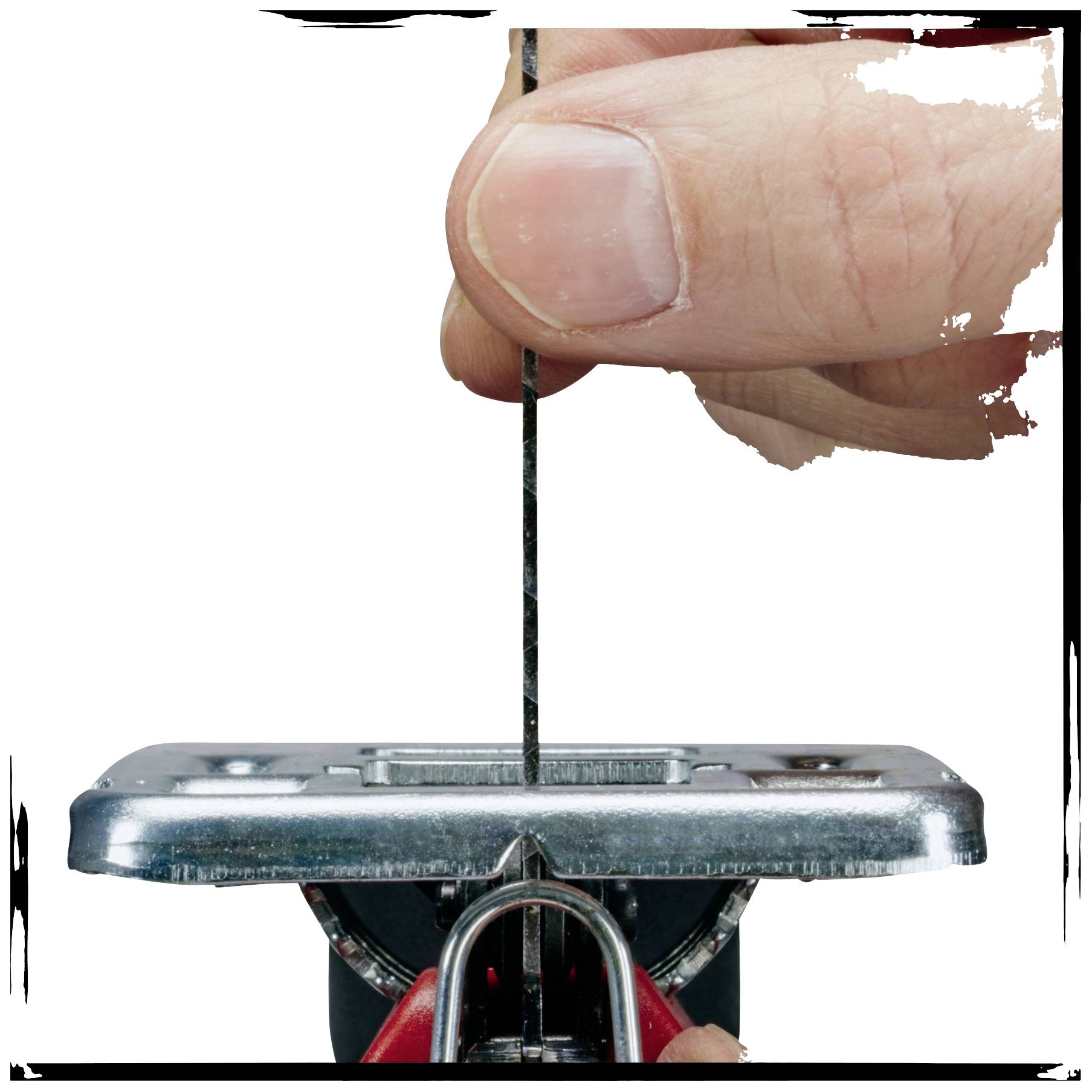 Gros plan d'un doigt insérant une lame de scie dans une scie sauteuse.