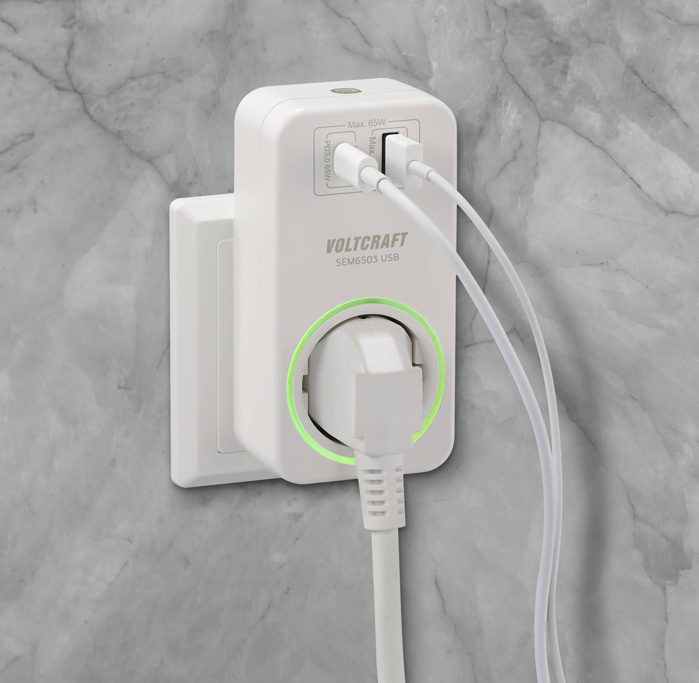 Un chargeur blanc multiports est branché dans une prise murale grise. Deux câbles USB y sont connectés.