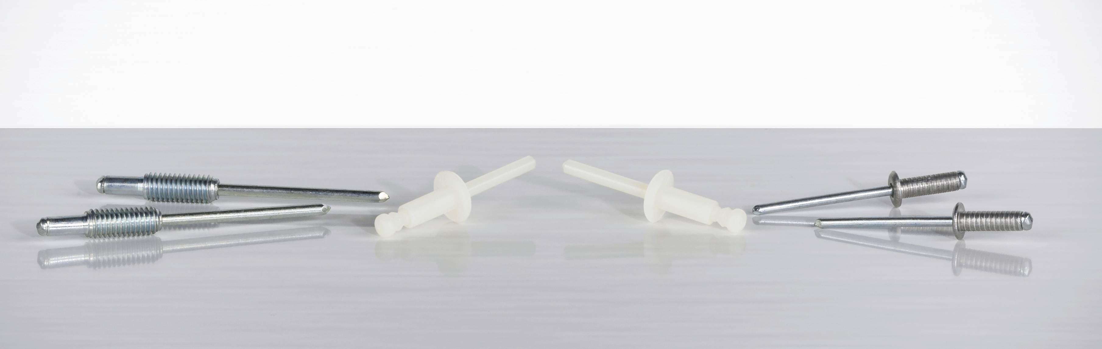 Bouchons métalliques et en plastique blanc disposés côte à côte sur une table.