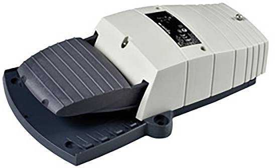 Pédale de commande dans un boîtier blanc sur un socle sombre, utilisée pour commander des machines par pression au pied.