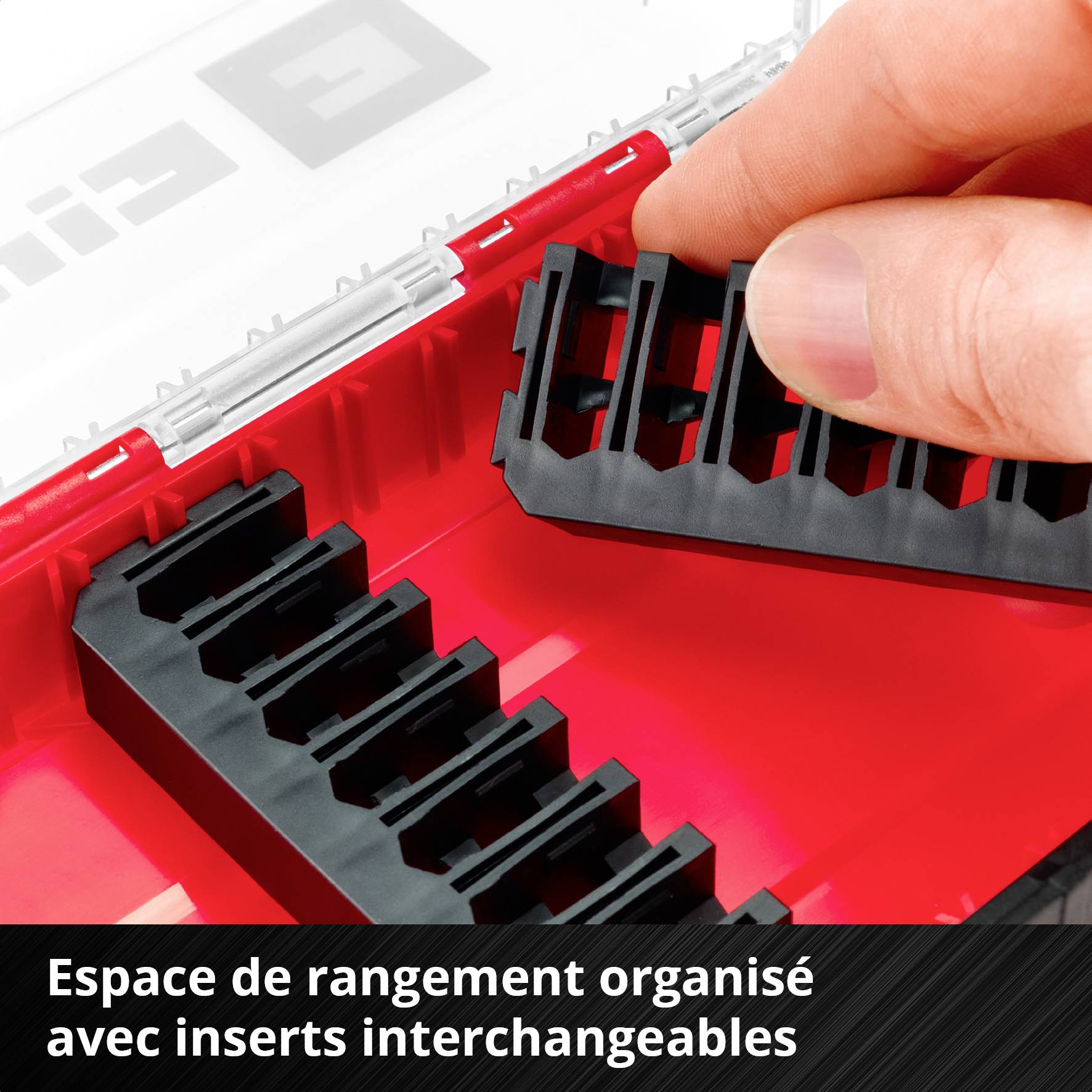 Une main retire l'insert noir d'un organiseur rouge à compartiments interchangeables.