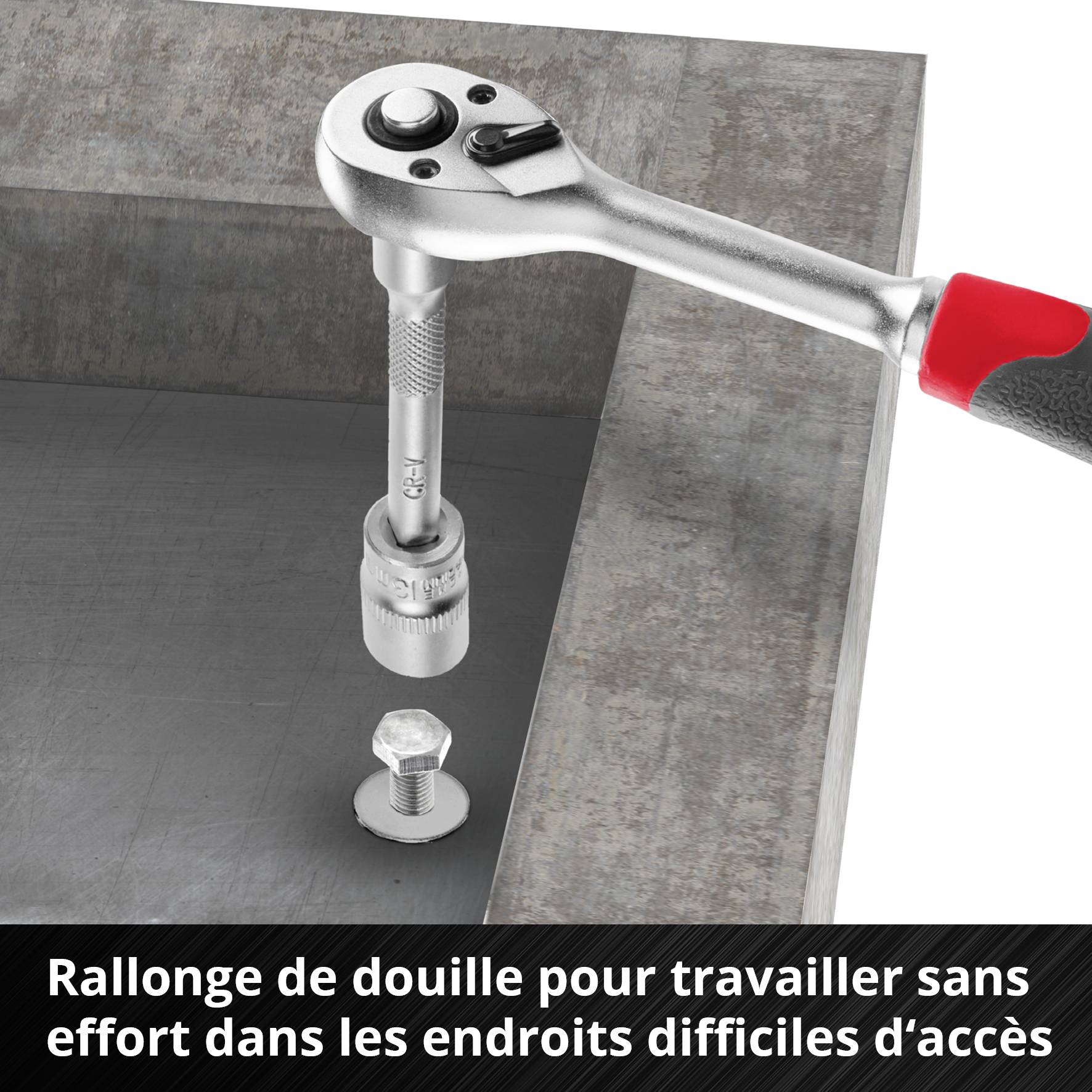 Une clé à cliquet avec une rallonge à douille serre une vis sur un cadre en acier difficile d'accès.