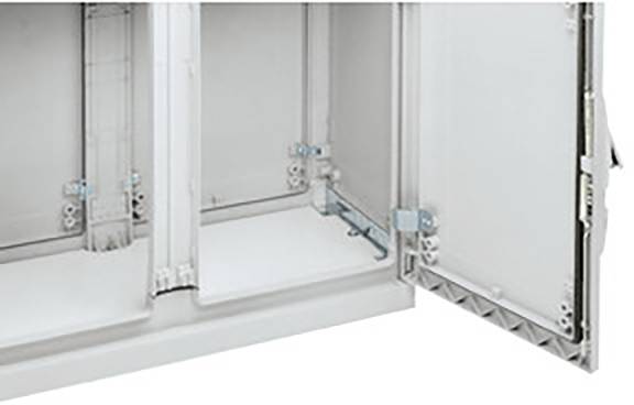 Une armoire électrique ouverte avec des charnières et des supports visibles. La porte est ouverte vers la droite.