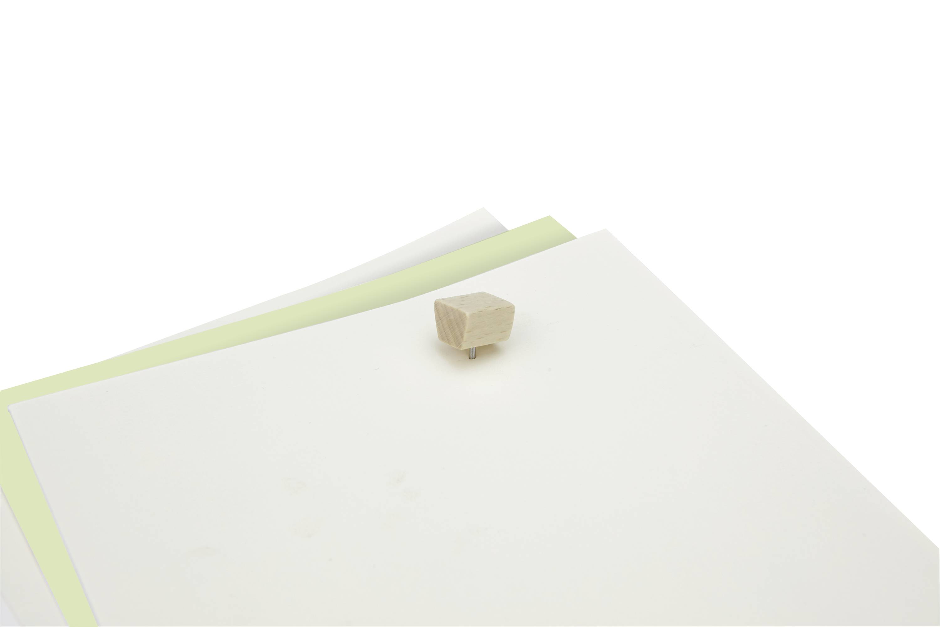 Un empilement de papiers blancs et verts est posé sur une table. Un petit bloc rectangulaire en bois repose sur ces feuilles.