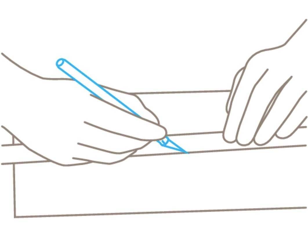 Des mains dessinent avec un stylo sur une feuille de papier posée sur une surface plane.