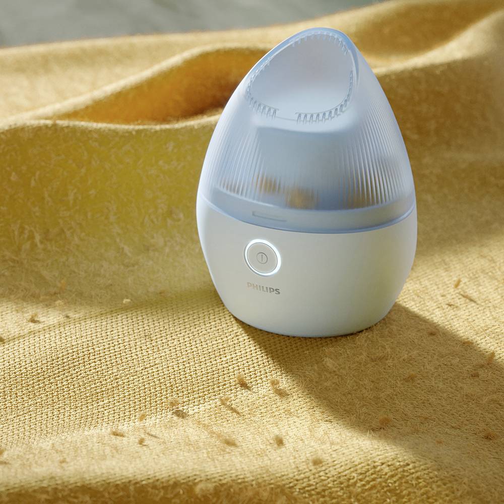 Un petit humidificateur lumineux est posé sur un tissu jaune.