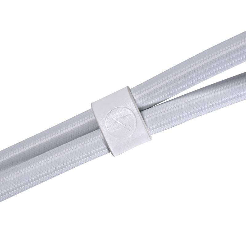 Un clip de gestion de câbles blanc qui maintient deux câbles blancs tressés, permettant une organisation de câbles propre et bien rangée.