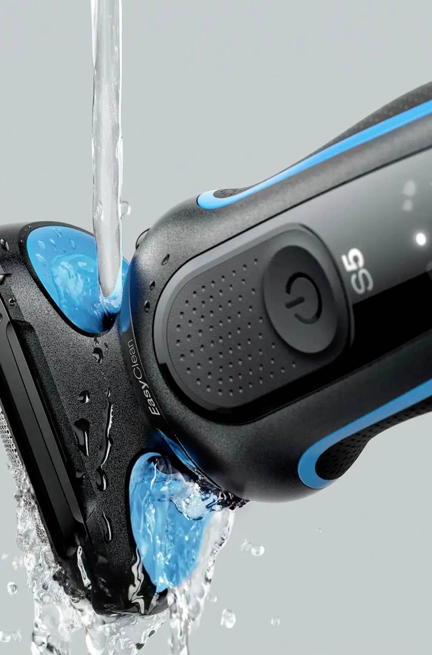 Rasoir électrique sous l'eau courante, démontrant sa fonction étanche. Le rasoir arbore un design moderne, noir et bleu.