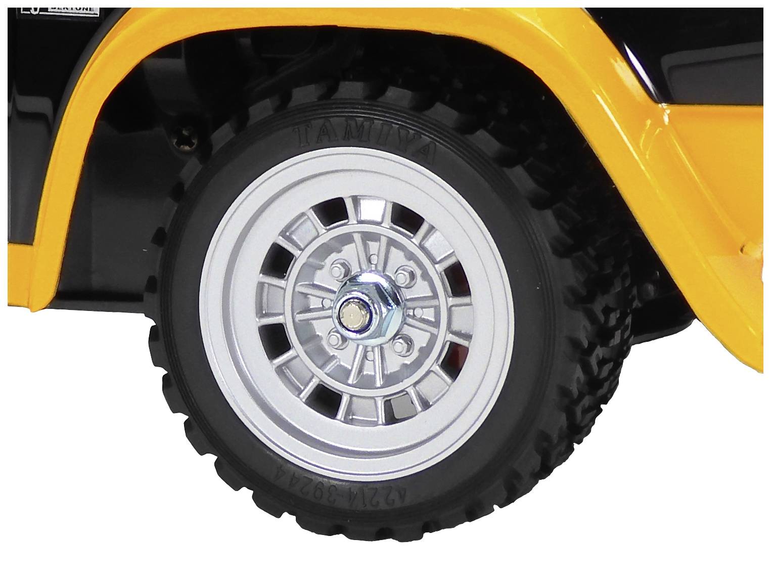 Une roue d'une voiture jouet avec un pneu noir et une jante argentée. La voiture est partiellement peinte en orange.