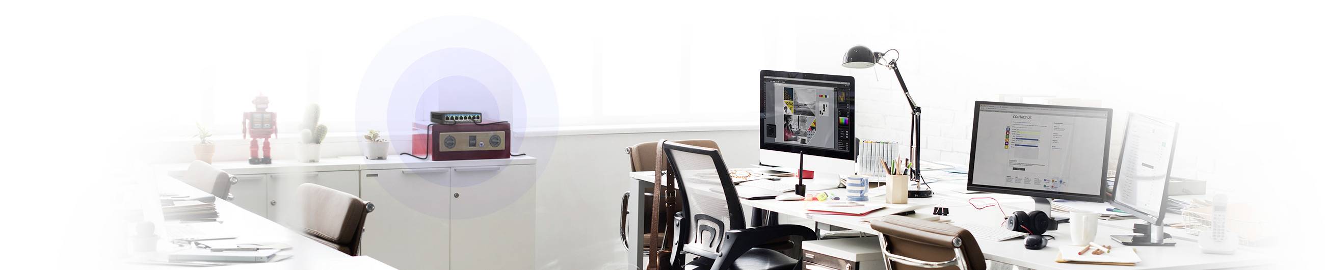 Un bureau moderne avec des bureaux, des écrans d'ordinateur et des chaises de bureau. L'espace est bien éclairé avec un design minimaliste.