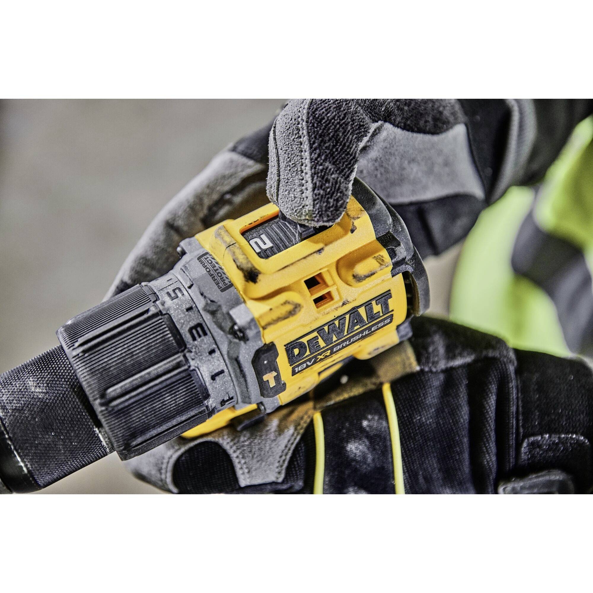 Une main tient une perceuse DeWalt, avec un focus sur le réglage du couple et le nom de la marque.