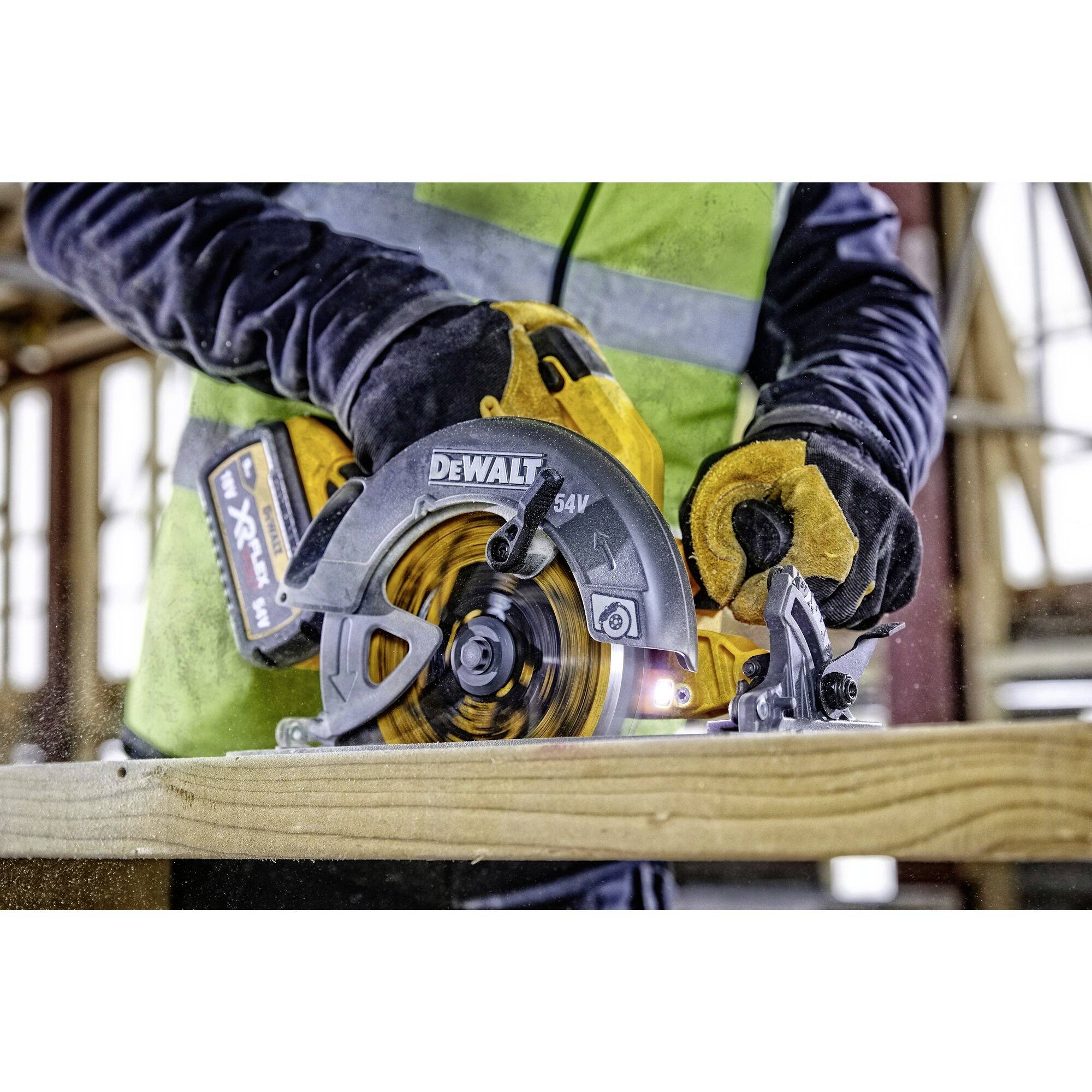 Une personne scie une planche en bois à l'aide d'une scie circulaire électrique portative. L'outil est une scie jaune DeWalt et est utilisé de manière sécurisée.
