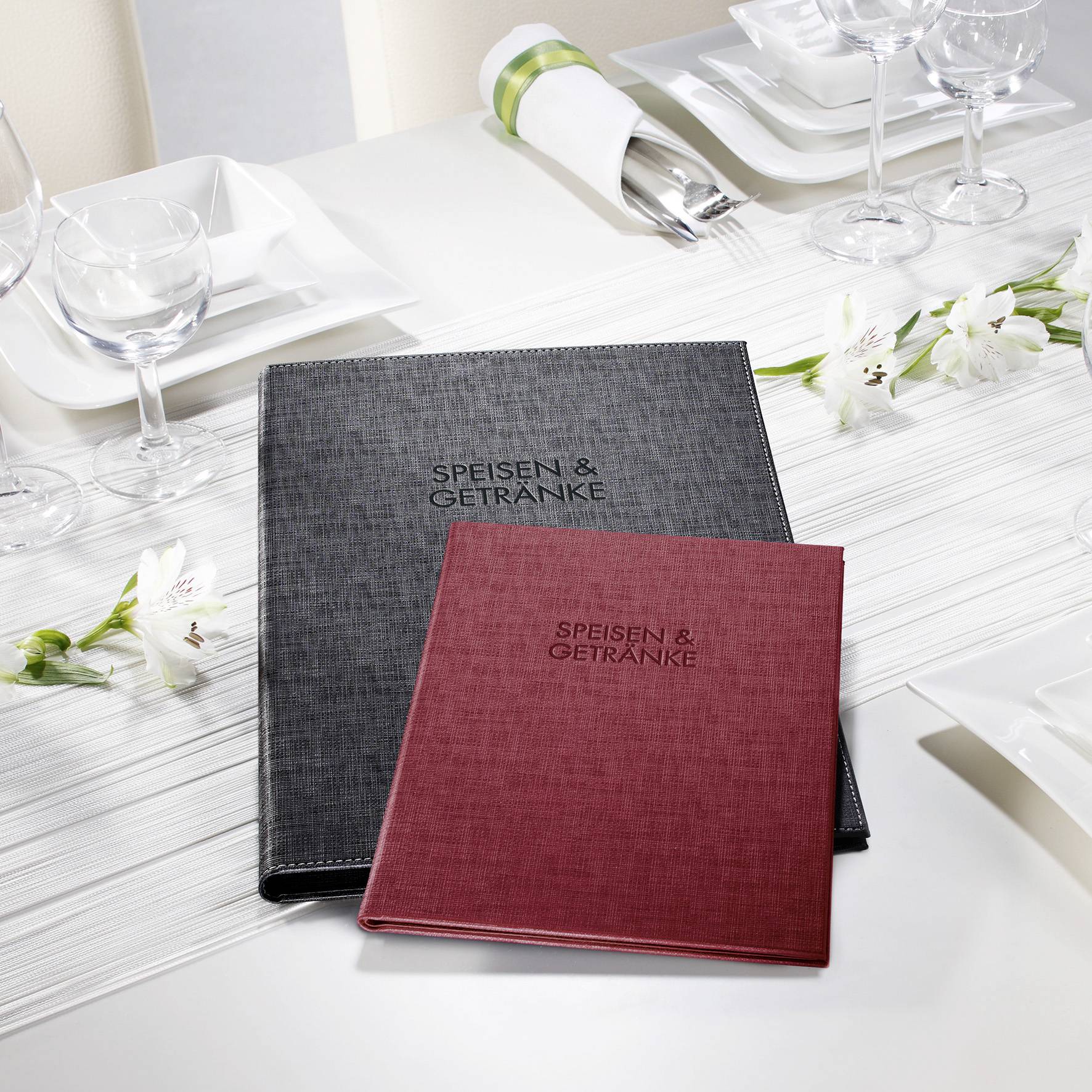 Décoration de table blanche avec des fleurs, des verres et des menus en noir et rouge portant l'inscription 'Plats & Boissons'.