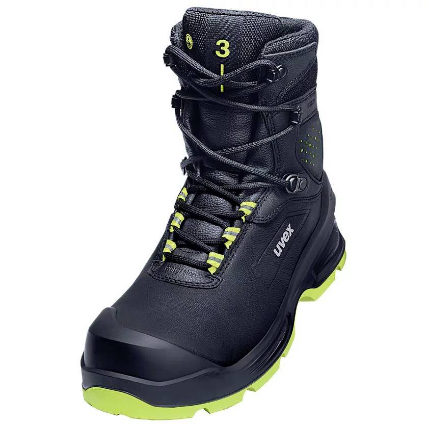Une chaussure de travail noire avec des détails verts et des lacets. La chaussure dispose d'un embout de protection renforcé et d'une semelle stable.