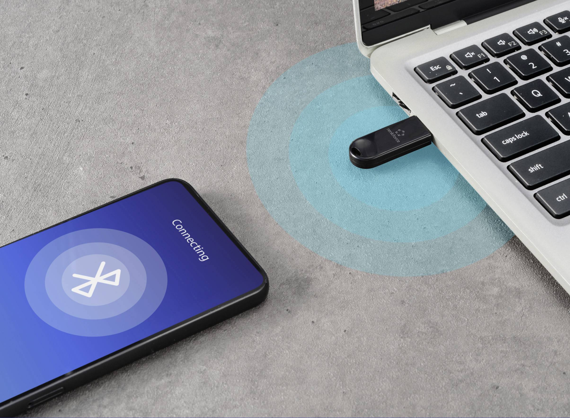 Un smartphone se connecte via Bluetooth à un ordinateur portable qui utilise un adaptateur USB. L'écran affiche 'Connecting'.