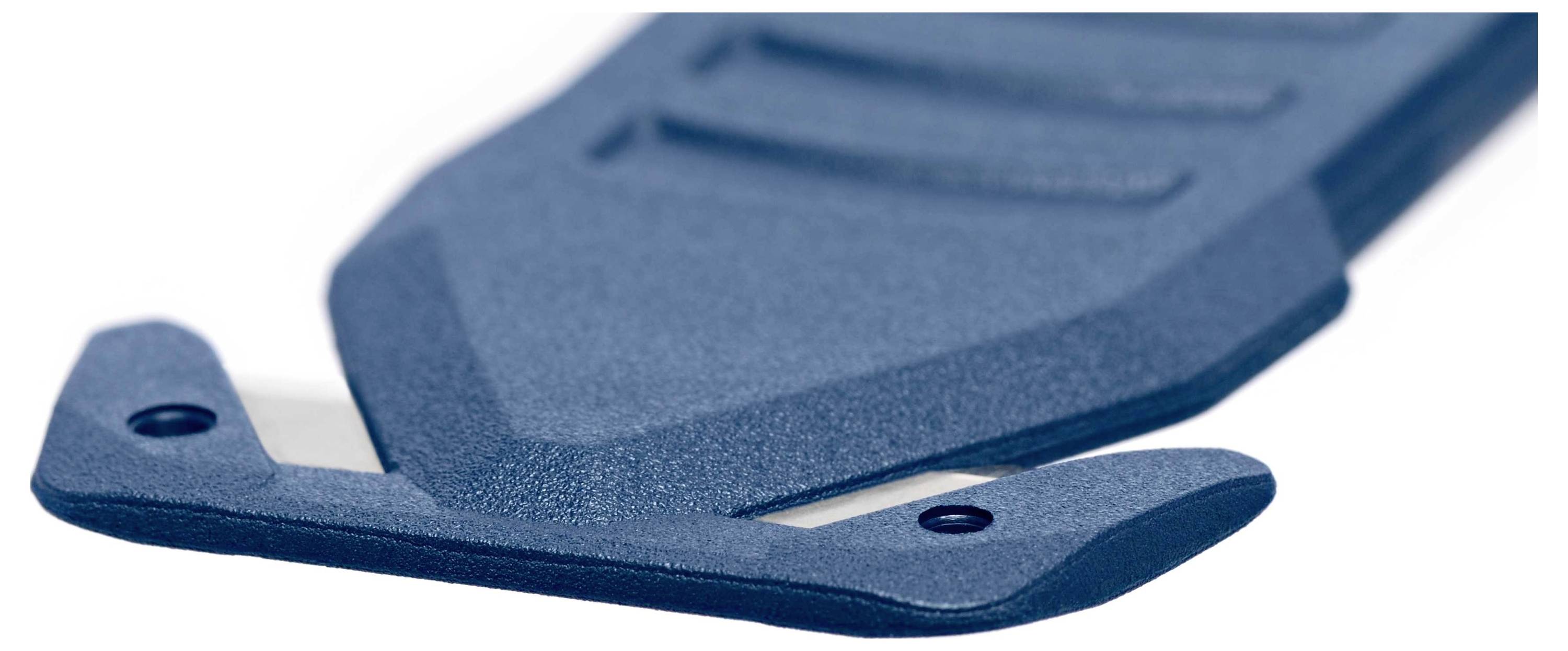 Gros plan sur une lame de coupe bleue à forme ergonomique, munie d'un capuchon de protection.