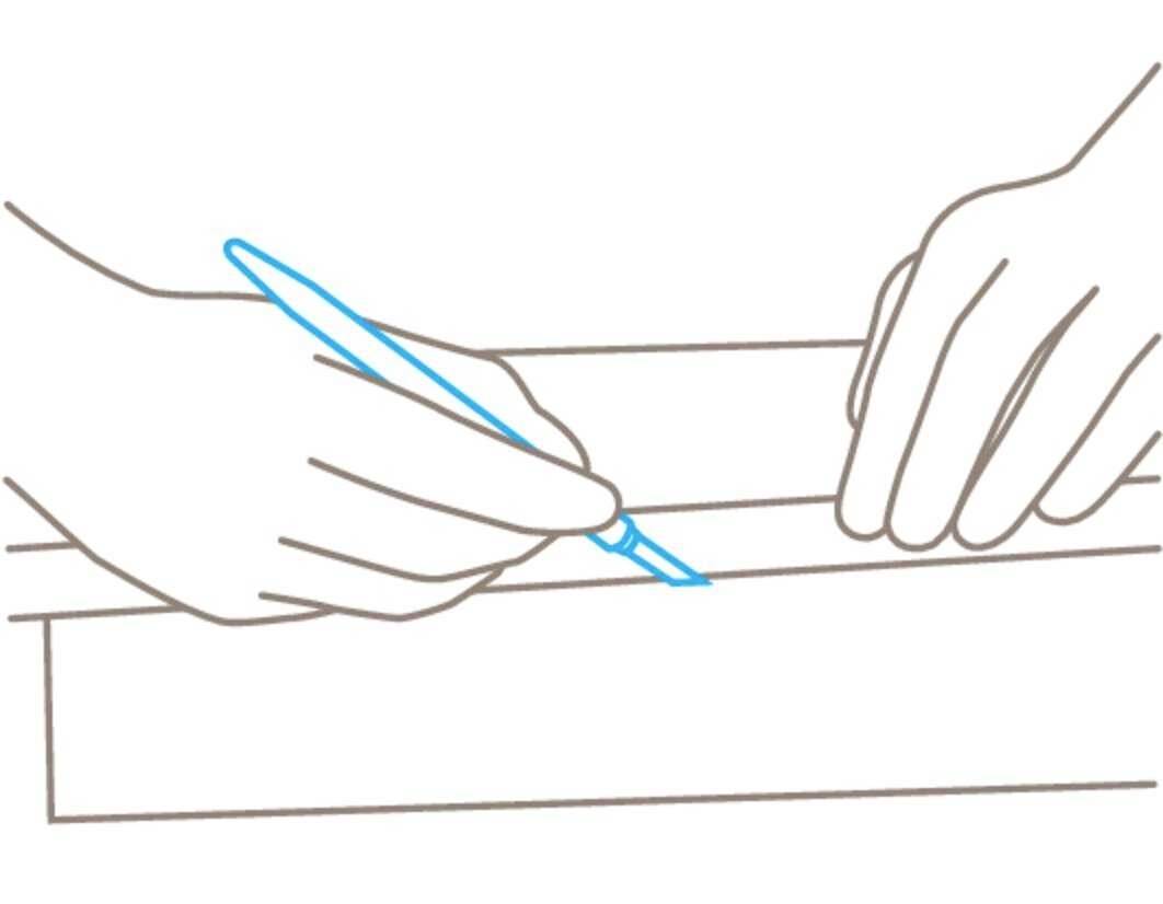 Une main tient un stylo et dessine une ligne sur un morceau de papier, tandis que l'autre main maintient le papier en place.