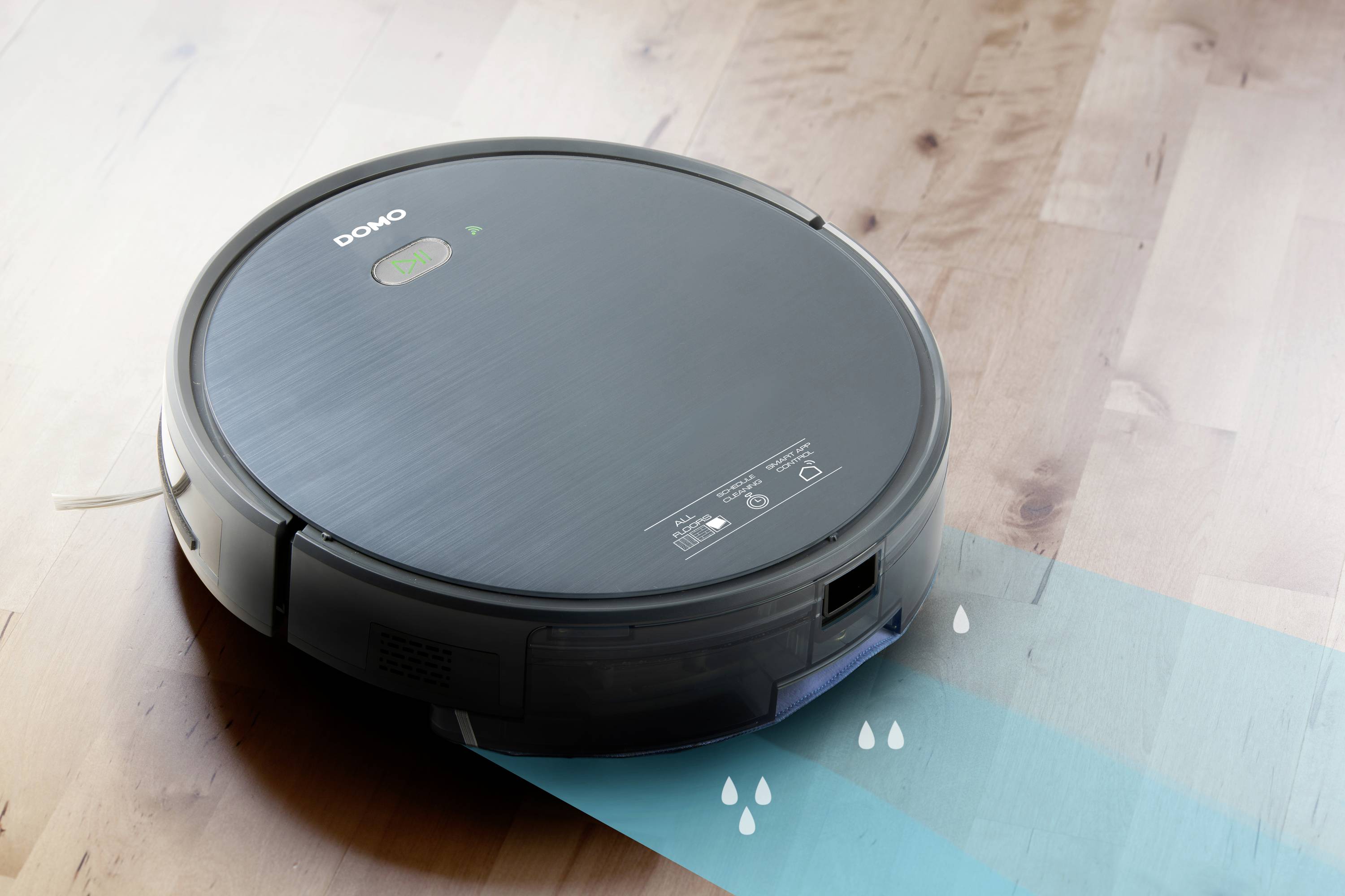 Un robot aspirateur rond passe sur un parquet, laissant une trace humide. Combinaison d'un réservoir à poussière et d'une serpillière.