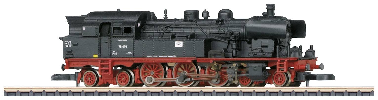Une locomotive à vapeur noire avec des roues rouges est stationnée sur une section de voie ferrée. Elle présente un design compact et robuste.