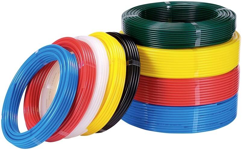 Plusieurs rouleaux de câbles isolés de différentes couleurs comme bleu, rouge, jaune, noir et vert, empilés les uns sur les autres.