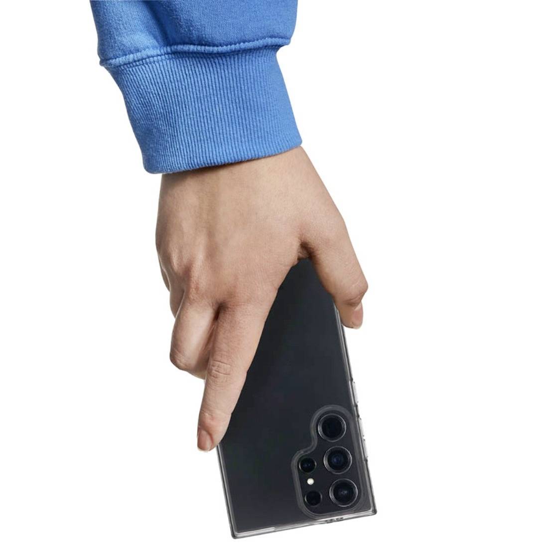 Une main tient un smartphone doté de plusieurs objectifs, placé dans un étui transparent. Le bras porte un pull bleu.