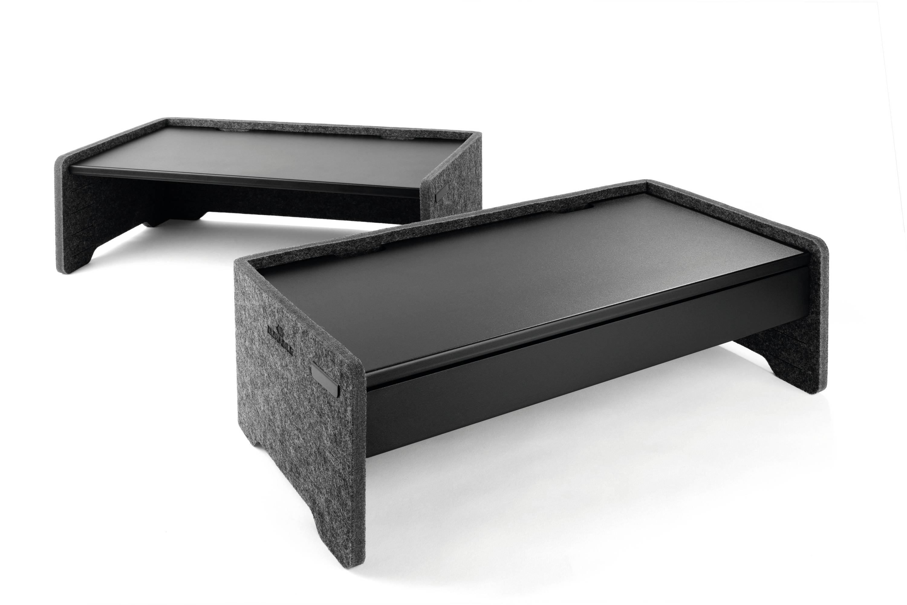 Deux supports de moniteur noirs avec un bord rembourré gris, légèrement inclinés, présentés sur un fond blanc.
