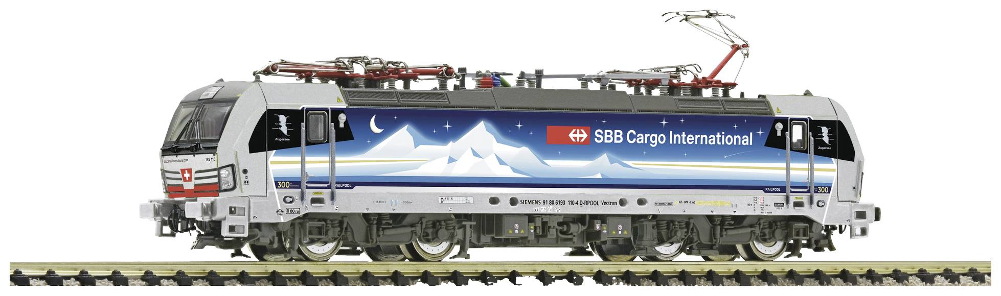 Un train de marchandises portant l'inscription 'SBB Cargo International' circule sur des rails. La locomotive arbore un motif de montagne sur son flanc.