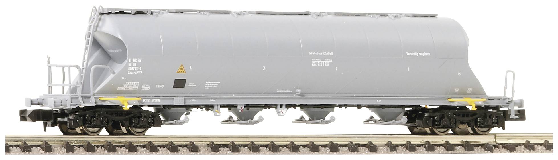 Wagon de fret gris sur des rails, vue latérale. Le wagon a un conteneur arrondi et fermé à des fins de transport.