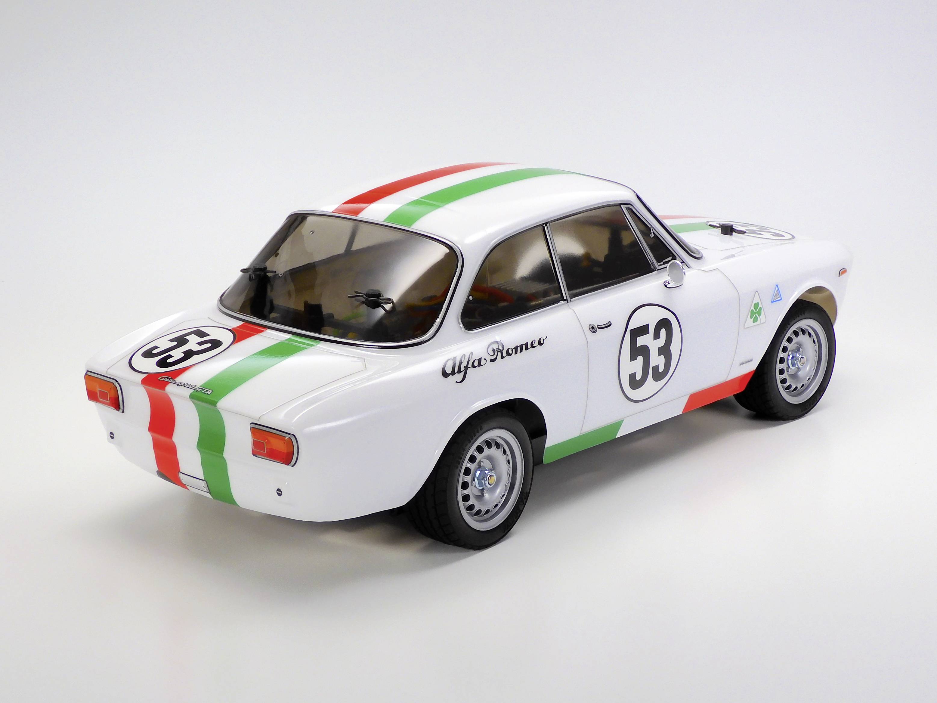 Une voiture miniature blanche de style rallye avec des bandes rouges et vertes. Le numéro '53' est inscrit sur la portière et le capot.