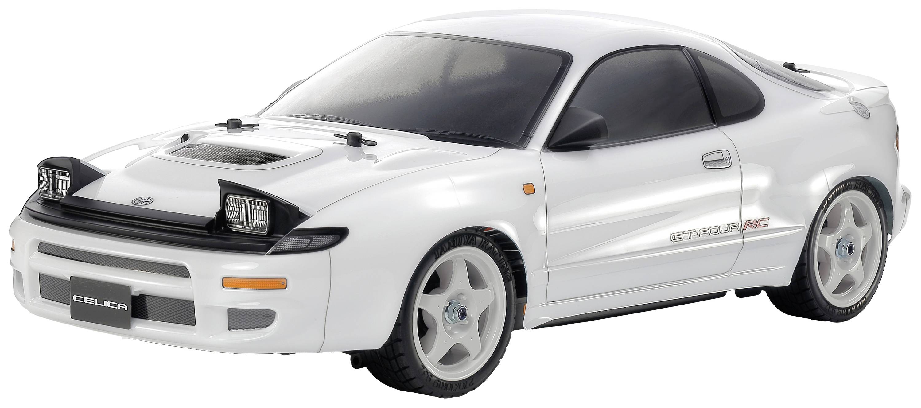 Une voiture miniature blanche au design sportif et aux phares marquants, sur laquelle est écrit 'Celica', est posée sur une surface.