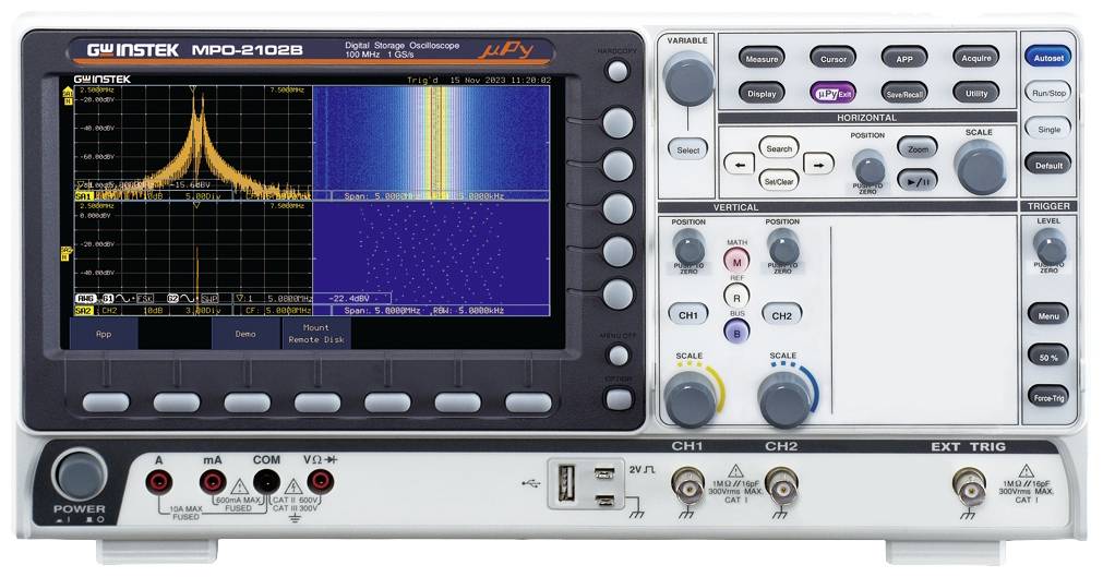 Oscilloscope numérique à deux canaux, affichant le spectre de fréquence et la forme d'onde du signal sur l'écran. Boutons de contrôle en dessous.