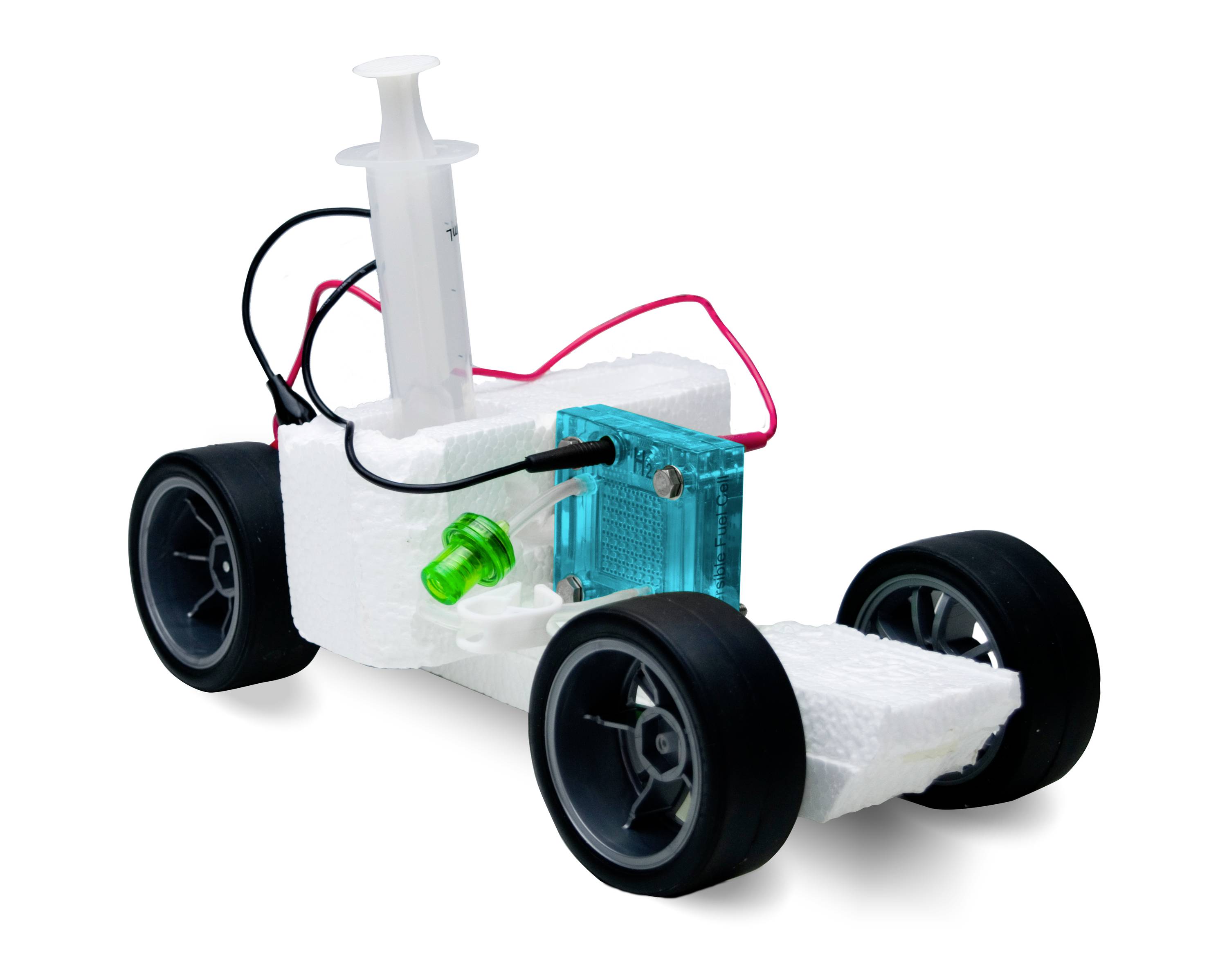 Un petit véhicule en polystyrène avec quatre roues, un boîtier en plastique et des câbles, probablement un modèle simple de robot ou de véhicule.