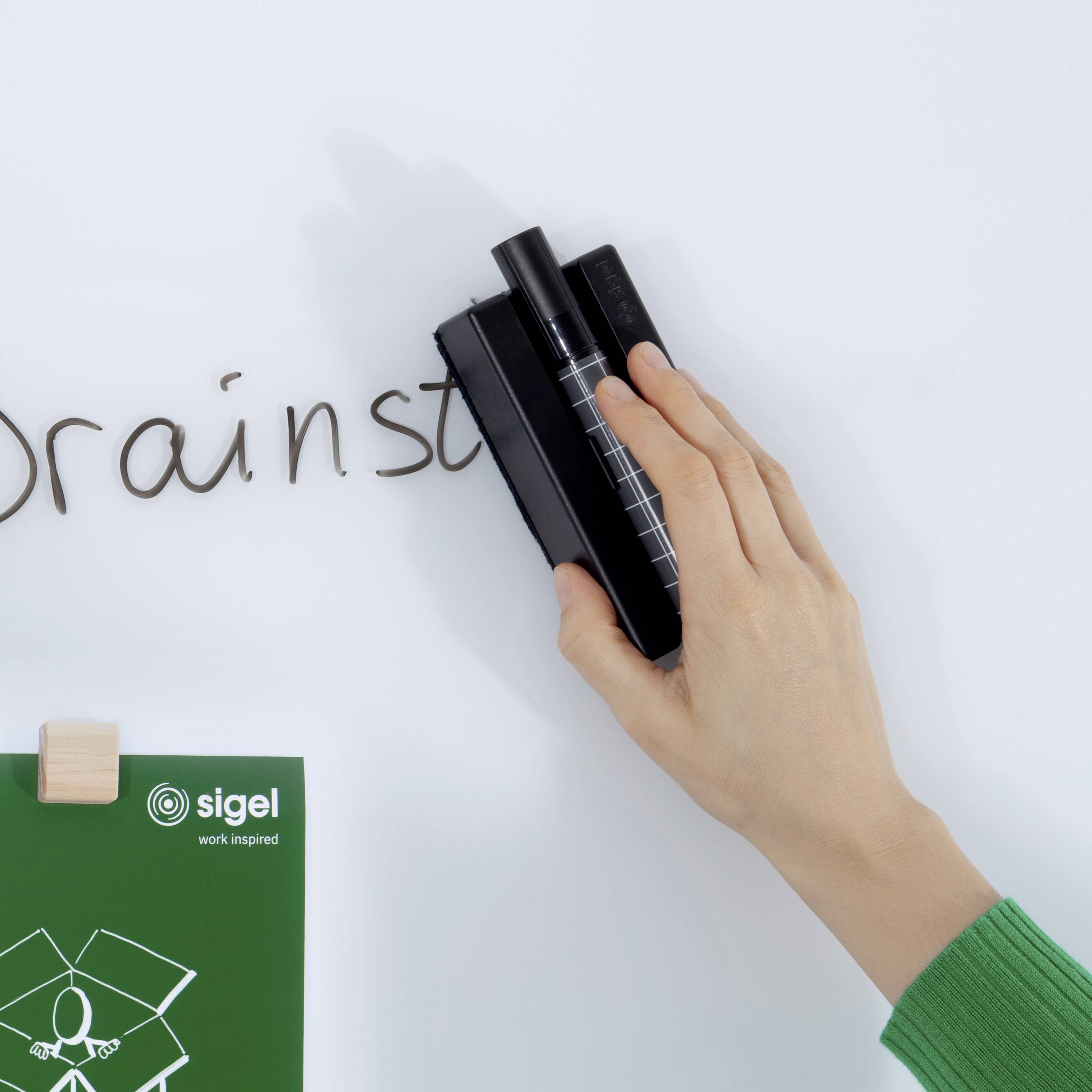Le mot « Brainstorming » est écrit sur un tableau blanc tandis qu'une main tient un stylo ; un logo portant l'inscription « Sigel » est visible en arrière-plan.