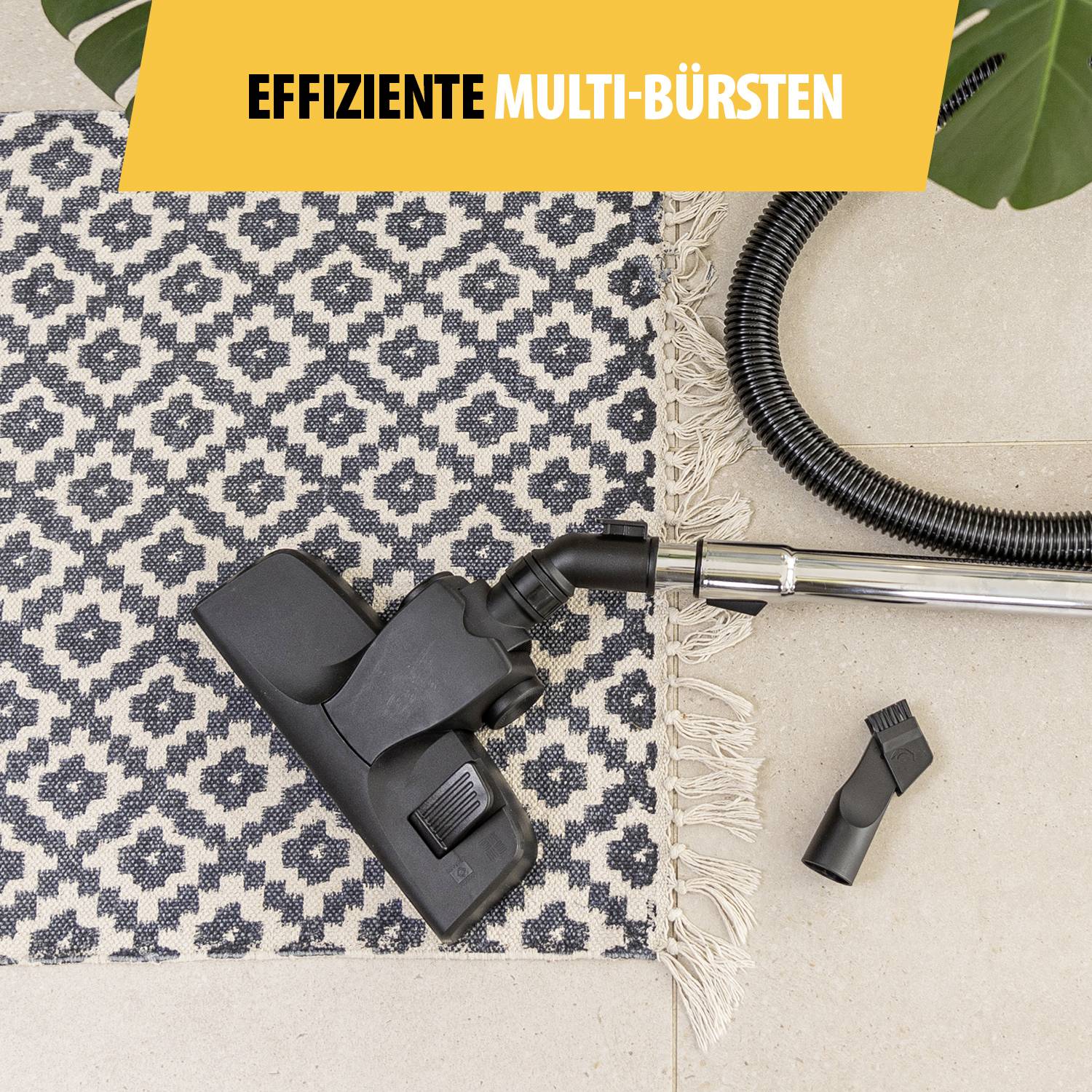 Une tête d'aspirateur et ses accessoires sur un tapis à motifs, avec une banderole 