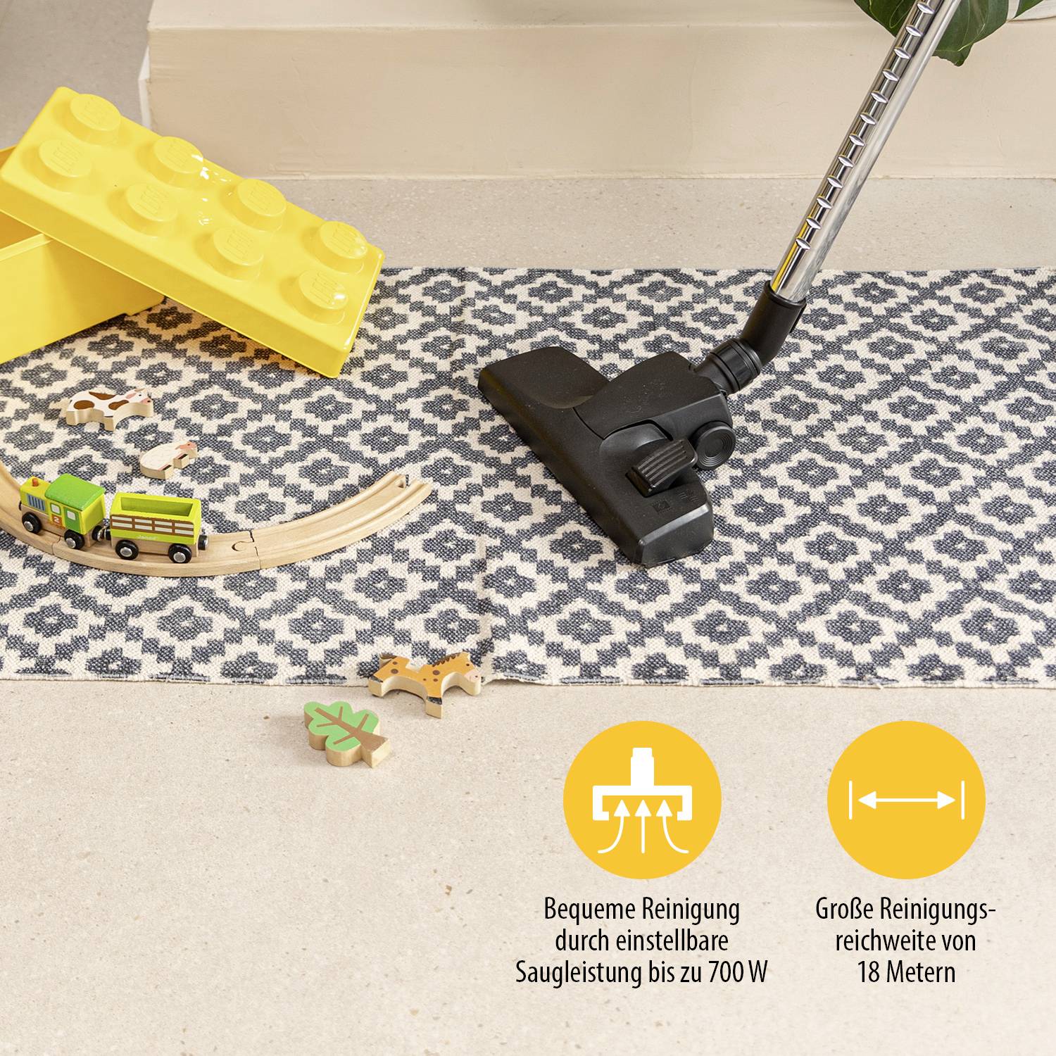 Un aspirateur nettoie un tapis sur lequel se trouvent des jouets. En bas à droite du texte : 'Nettoyage pratique', 'Portée de 18 mètres'.
