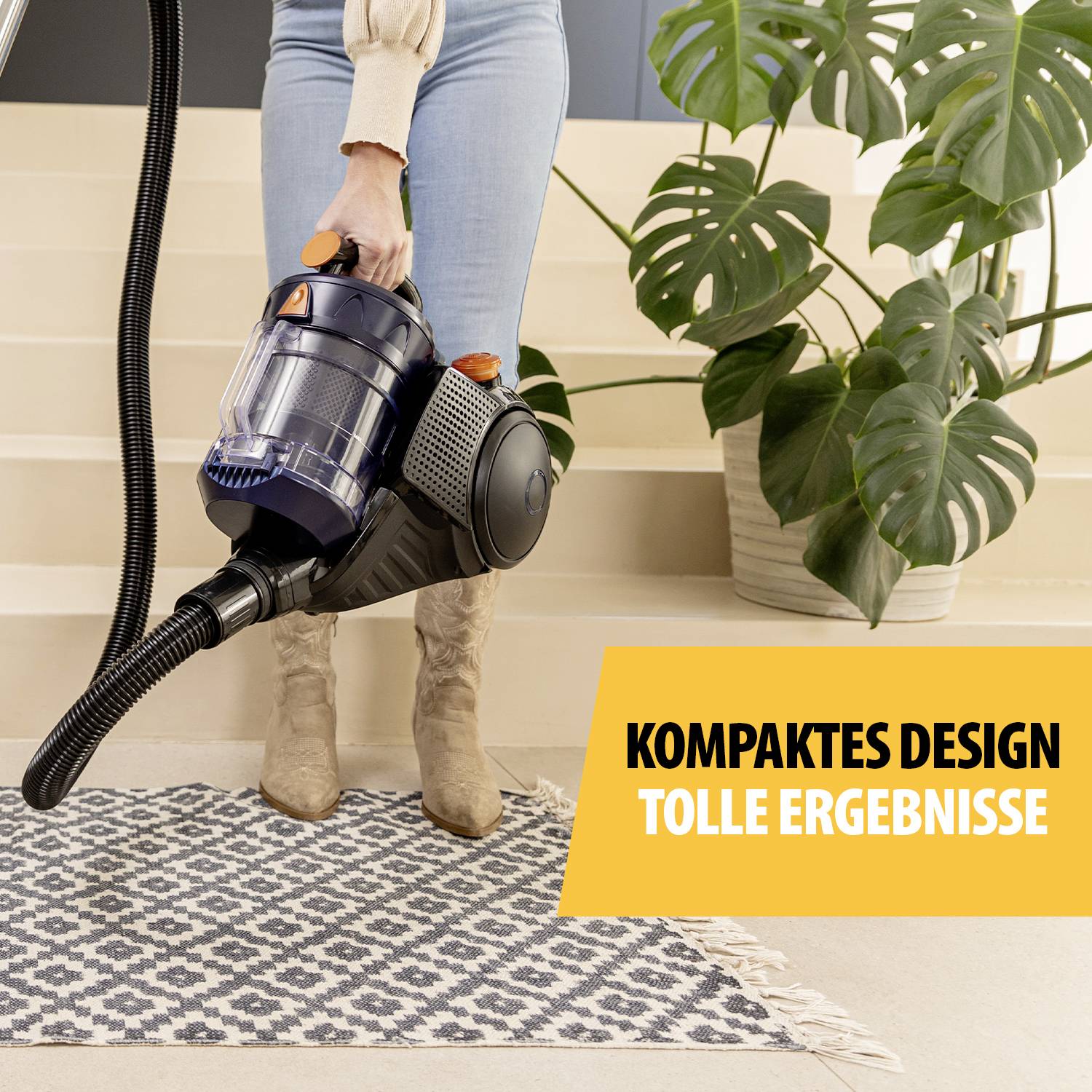 Une personne passe l'aspirateur sur un tapis à motifs. Une plante se trouve à droite. Une bannière jaune indique : 'Design compact, résultats impressionnants'.