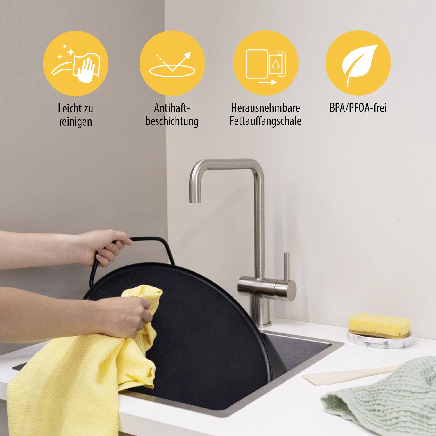 Une personne nettoie un grand appareil de cuisson rond. Au-dessus, quatre symboles sont affichés : 'Facile à nettoyer', 'Revêtement antiadhésif', 'Bac récupérateur de graisse amovible', 'Sans BPA/PFOA'.