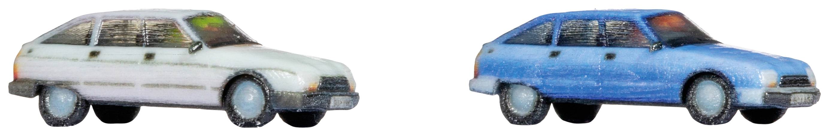 Deux petites voitures jouets, l'une blanche à gauche et l'autre bleue à droite, sont côte à côte. Les deux sont légèrement usées et représentées de manière stylisée.