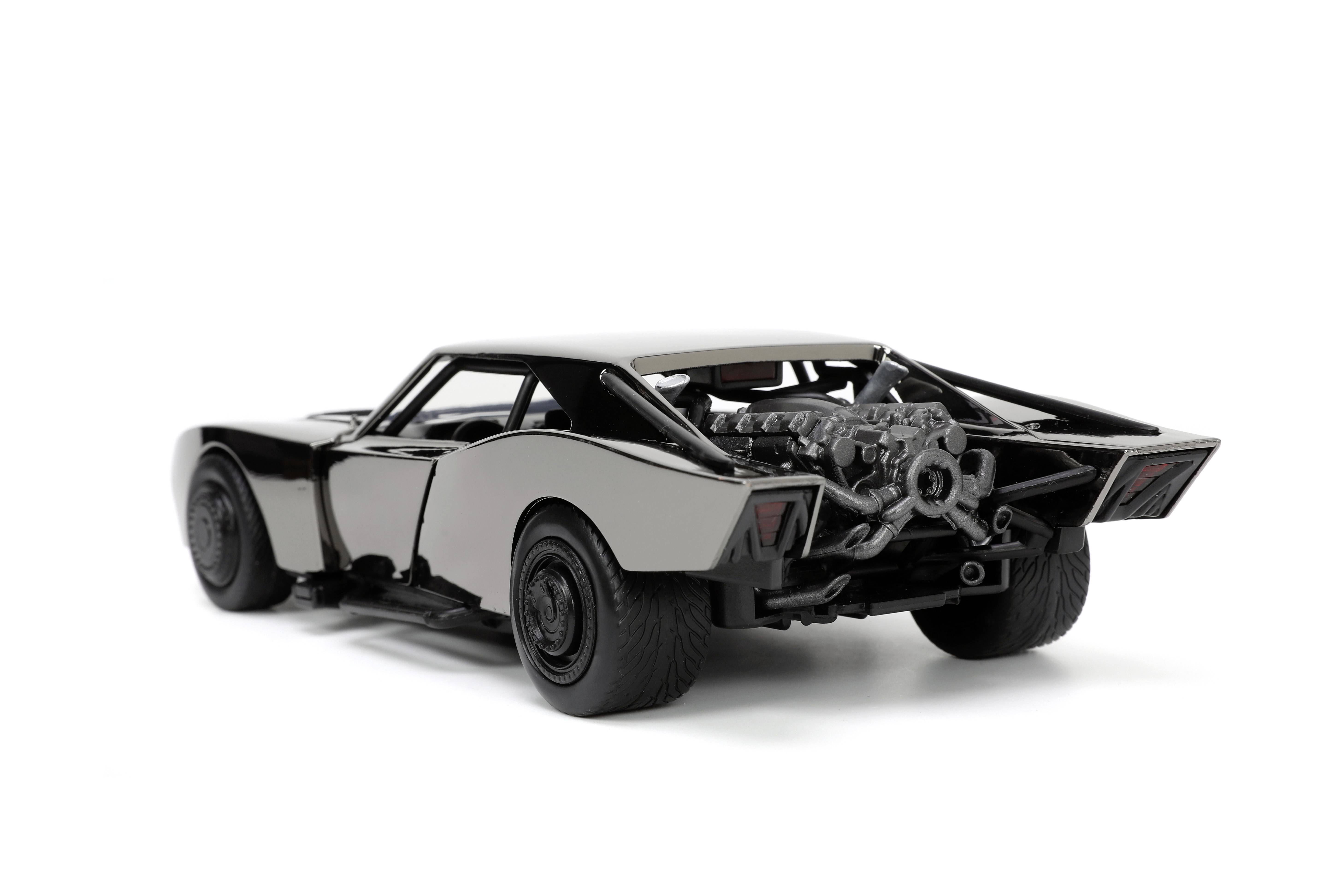 Une voiture miniature noire vue de l'arrière, montrant les détails du moteur ouvert et l'aileron arrière distinctif, sur un fond blanc.