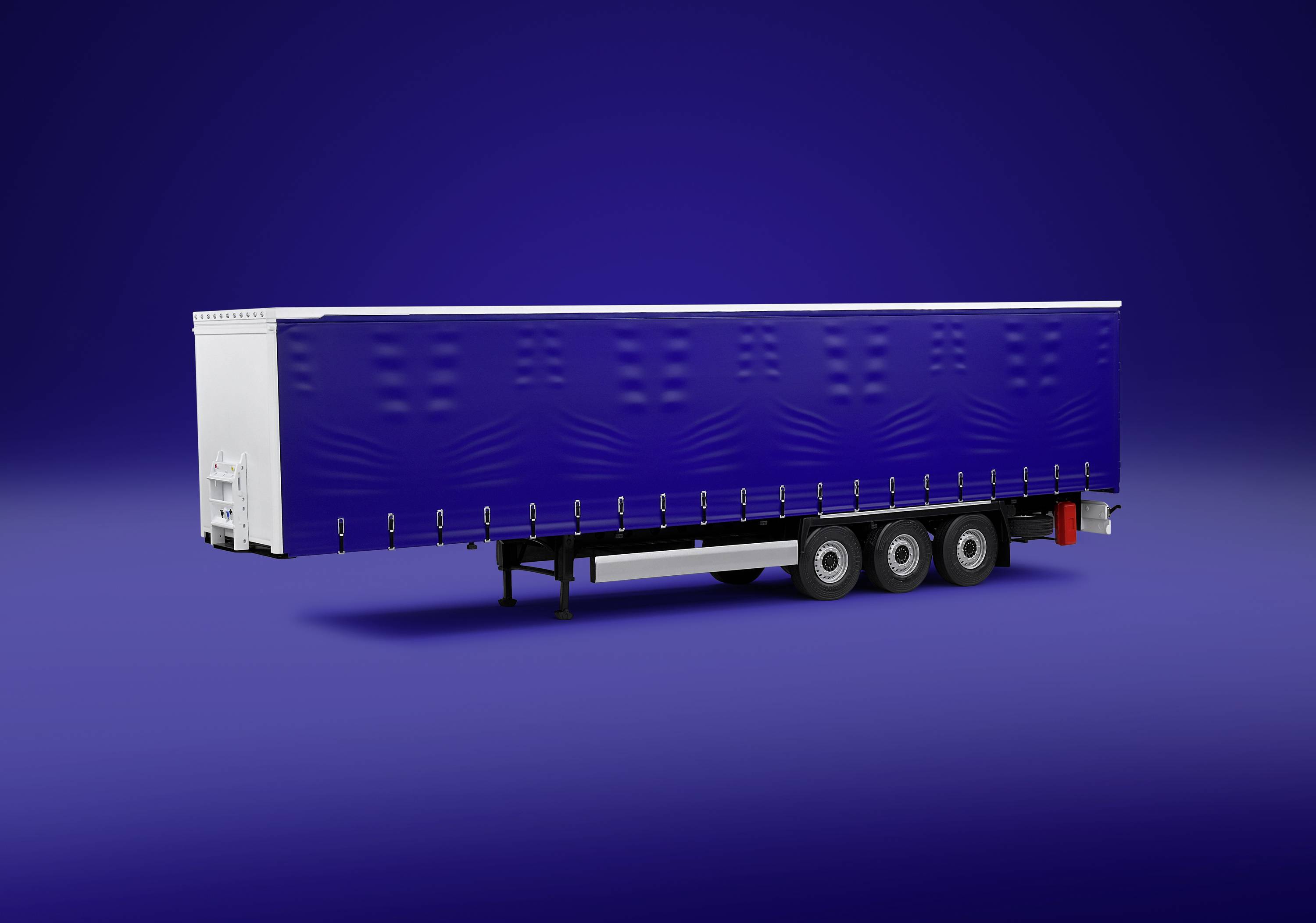 Un remorque de camion bleue avec des éléments blancs est placée devant un arrière-plan uni bleu.